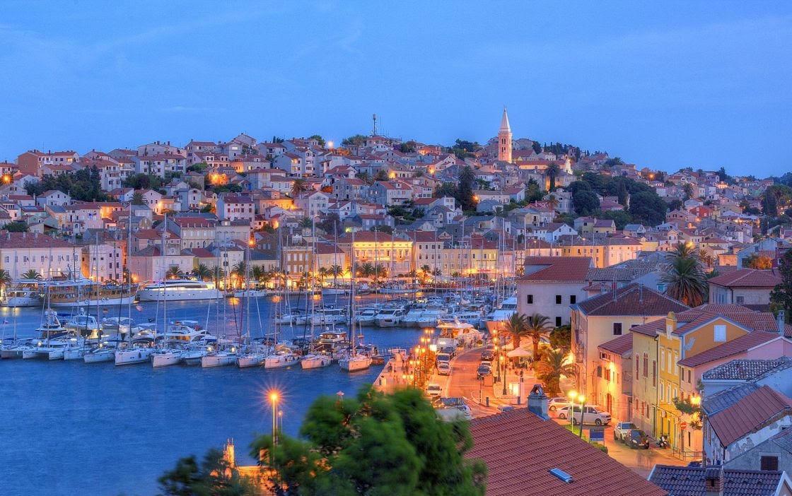 Lošinj harbour and old town at dusk with lights reflecting on the sea